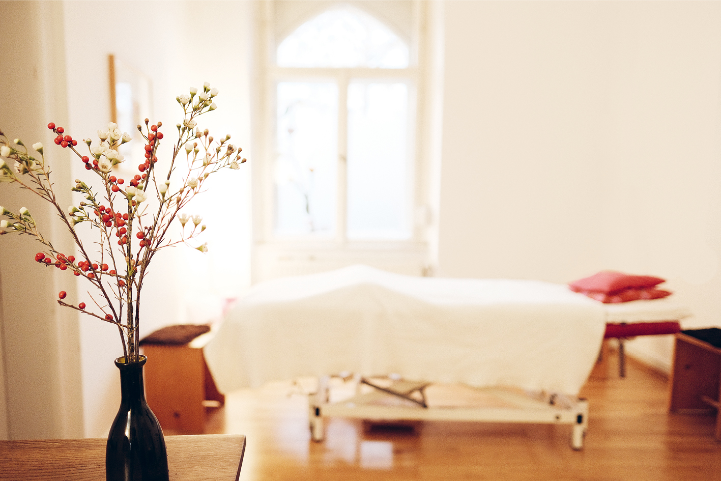 Behandlungsraum der Praxis Grundler mit Blumen und Behandlungsliege